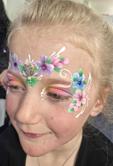 Girl with flower face paint at a party in Telford